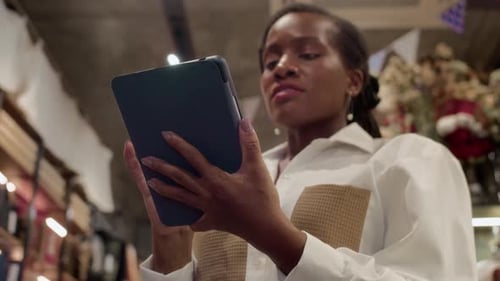 Woman Analyzing Inventory with Tablet in Department Store