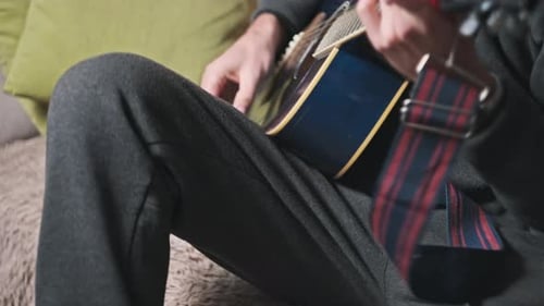 Man Playing Acoustic Guitar at Home