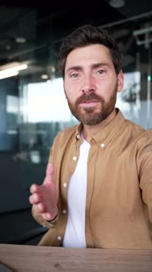 POV Vertical. Businessman talking on a video call using phone in modern business office. Handsome