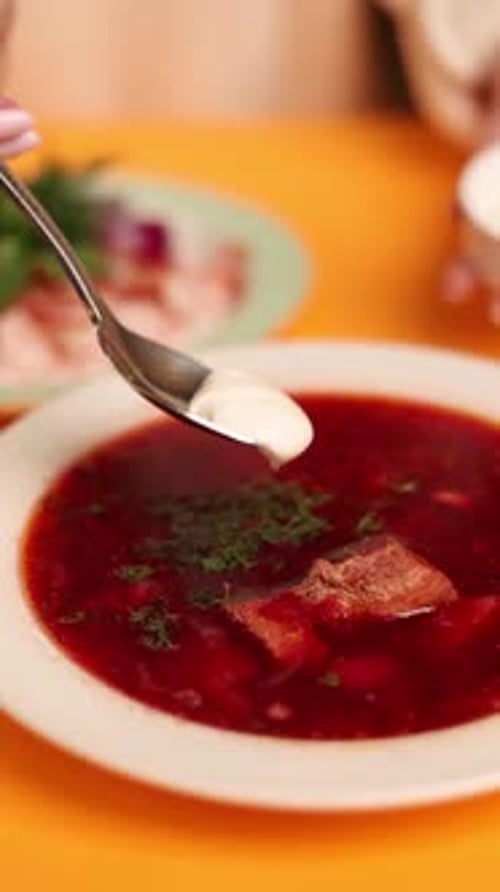 Un plato de borsch ucraniano sobre un fondo naranja