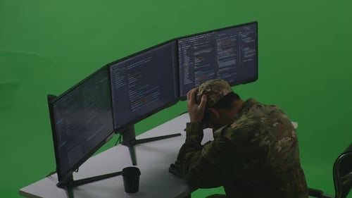 Side View Of Man Soldier Having Headache While Write Code With Multiple Screens In Green Screen