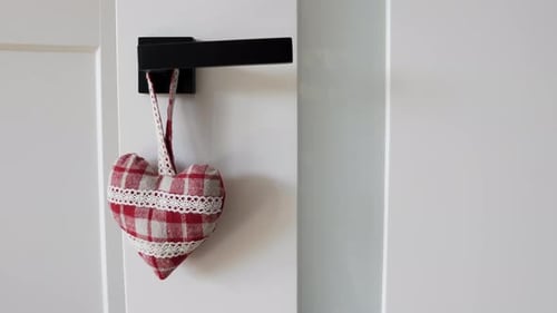 Review of a heart shaped door hanger hanging on a black handle. Valentines day door handle hanger. W