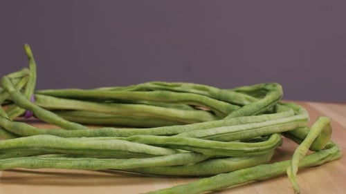 A Pile of Fresh Green Beans a Staple Food Ingredient Rests on a Wooden Cutting Board These Natural