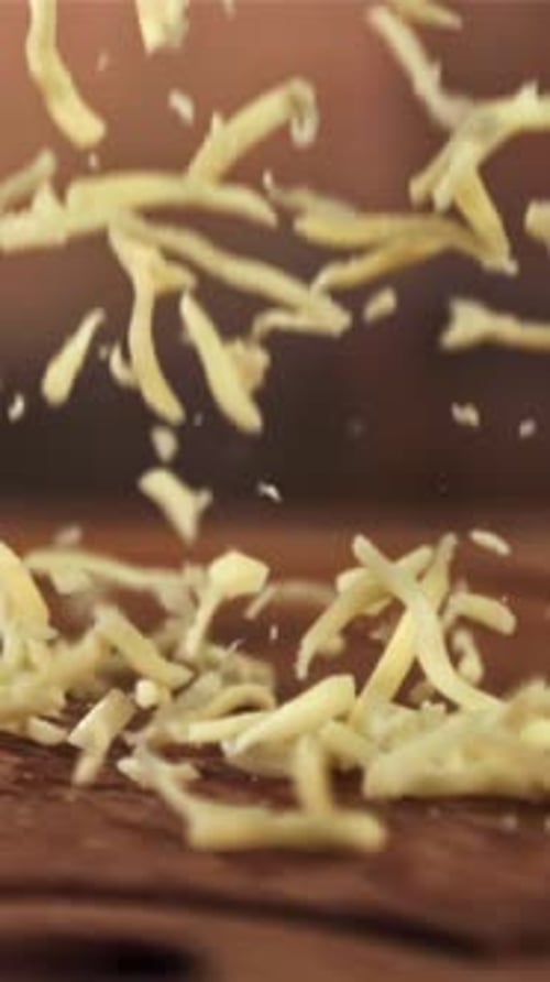 The Grated Cheese Falls on a Wooden Board Filmed on a Highspeed Camera at 1000 Fps