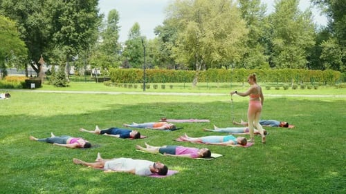 Yogi Woman Playing Swinging Chimes During Yoga Meditation in City Park