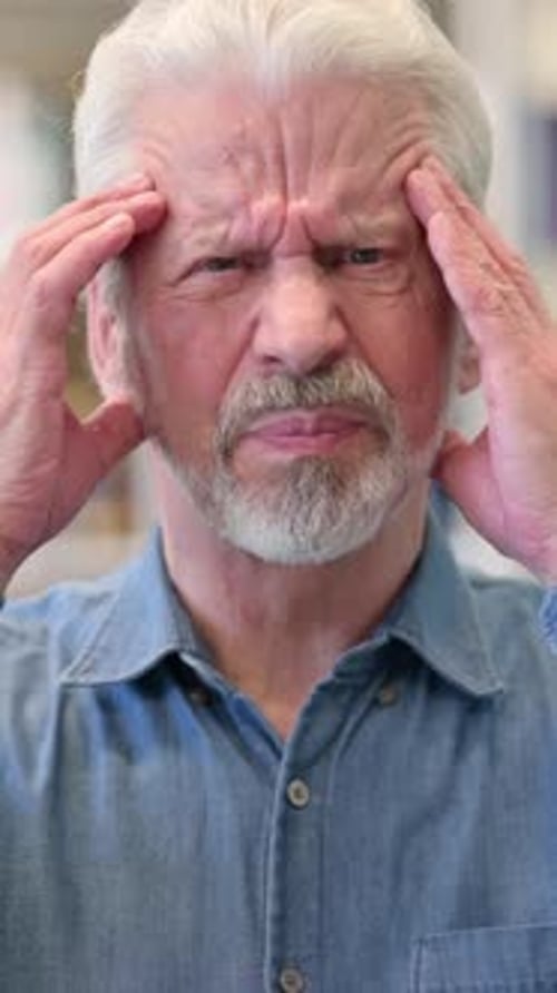 Senior Man Massaging Temples in Distress Close-Up Portrait