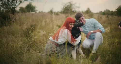 Young couple with dog in a field