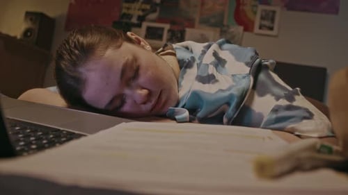 Young Woman Sleeping on Desk at Night