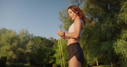 Sporty Woman Using Exercise Band in Green Park
