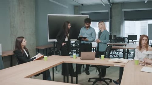 Discussion among business professionals in a modern office setting while reviewing project details