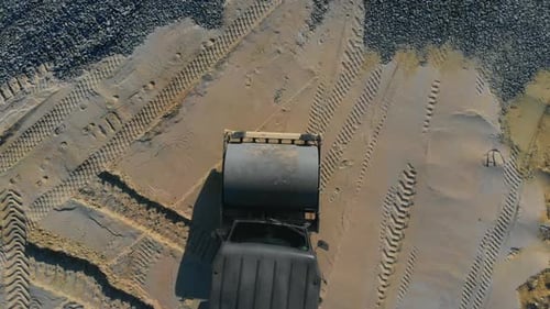 Foto de cima para baixo do veículo escavador se movendo pela área de construção do canteiro de obras para novas indústrias