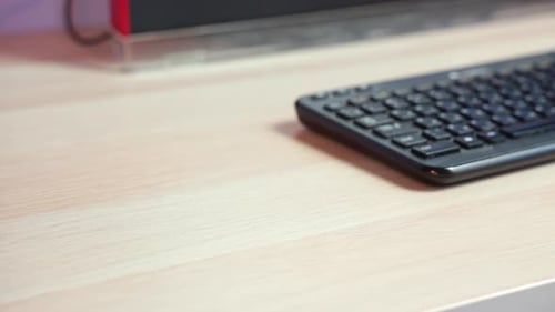 Eine Nahaufnahme zeigt eine Hand, die Tasten von einem Schreibtisch neben einer Tastatur auswählt