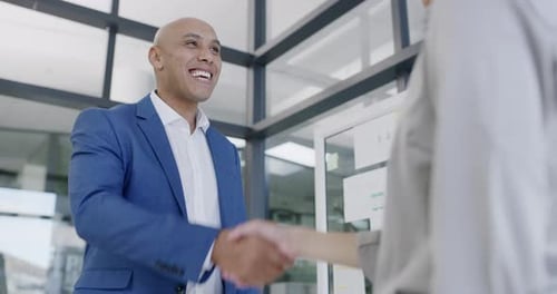 4k video footage of a mature businessman shaking hands with a colleague in an office