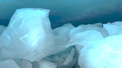 Glatte Eisbrocken in der Eishöhle unter dem Brewster-Gletscher. Eis schmilzt, Wasser tropft
.