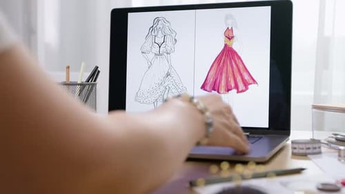 Designer of women's clothing, dresses, develops sketches using a laptop. Fashion concept.
