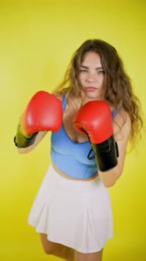 Woman Boxing Poses with Red Gloves in Studio
