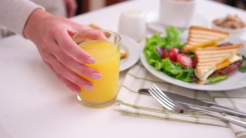 Breakfast Table with Delicious Sandwiches and Orange Juice