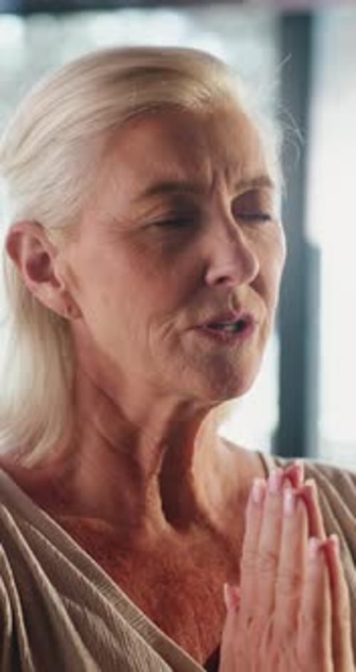 Senior Woman Meditating Peacefully with Hands in Prayer Position