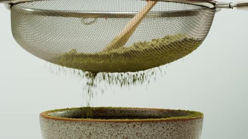 Matcha Green Tea Cooking Process Japanese Powder Green Tea in a Bowl with Bamboo Whisk Macro Close