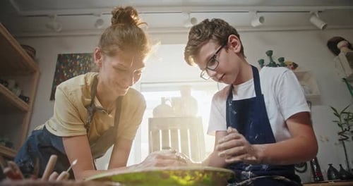 Woman and Teen Shaping Clay at Pottery Wheel