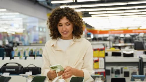 Customer Testing Smartphone in Electronics Store