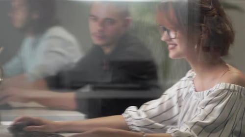 Young Businesswoman Discussing with Colleague Over Desktop Pc in Office