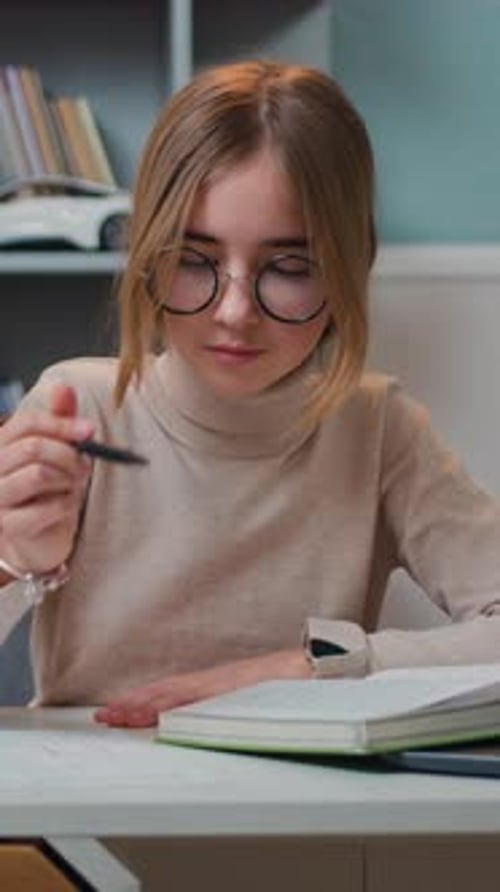Girl with Glasses Studying and Writing at Desk