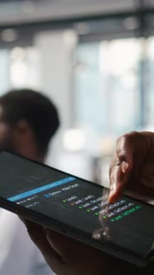Vertical Video Close Up of Programmer Utilizing AI on Tablet to Optimize Performance