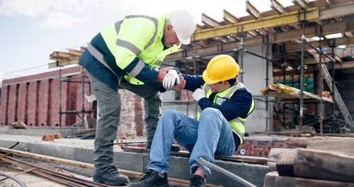 Men, pain and construction workers on site with injury, accident or hurt by building repairs