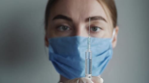 Woman with Injection Needle Wearing Mask in Hospital