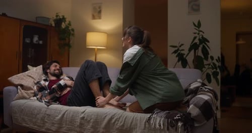 Woman Gives Foot Massage to Man at Home