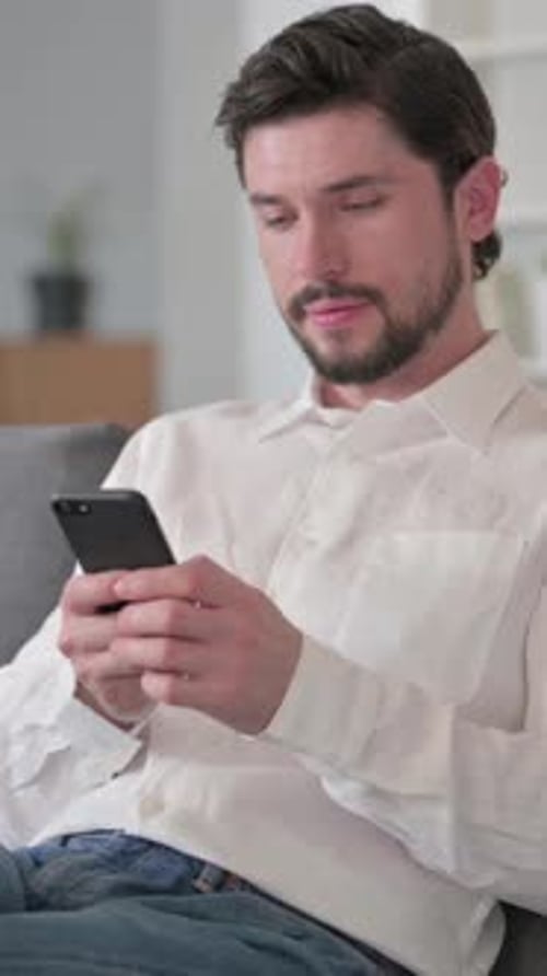 Man Using Smartphone While Sitting on Couch