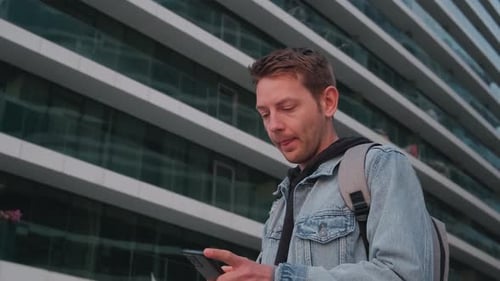 Young Handsome Man Using Smartphone Outdoor in a City Caucasian Guy Texting on His Mobile Phone at
