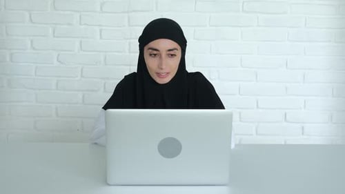 Woman Video Conferencing on Laptop at Home