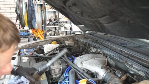 Mechanic Working on Car Engine in Garage