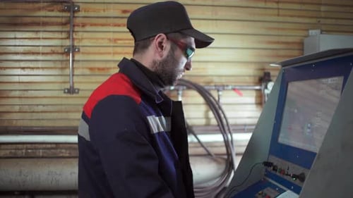 Industrial Worker Operating Control Panel in Factory