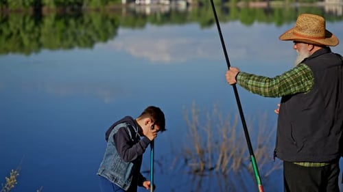 Family Vacation Grandfather Holding Fishing Rod with Small Grandson at the Lake Concept of Happy