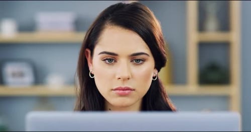 4k video footage of an attractive young businesswoman working on a laptop in her home office