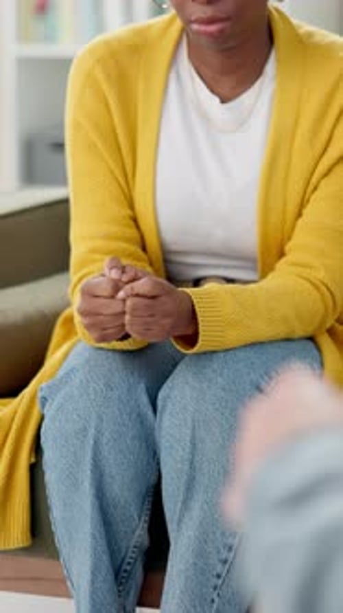 Woman Sits Indoors in Yellow Cardigan