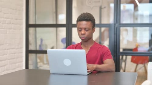 Young Adult on Video Call Using Laptop in Office