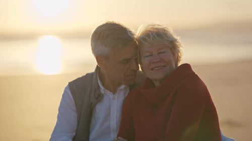 Senior Couple Sharing Intimate Moments at Sunset on Beach