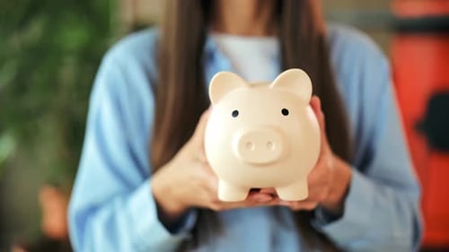 Happy Woman Saves Money with Piggy Bank Demonstrating Financial Planning