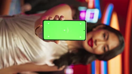 Vertical Screen: Advertising Template with an Asian Female Showing a Smartphone with a Green Scree