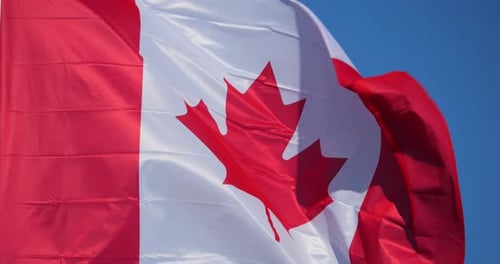 Canadian Flag Waving Against a Blue Sky