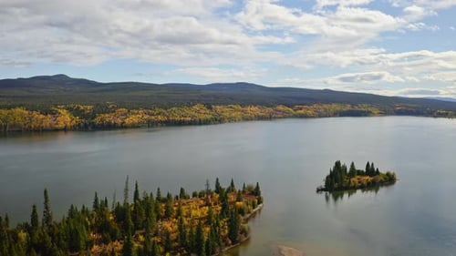 Vast lake with autumn fall colours. Hills in background. Summer day in British Colombia, Canada