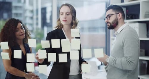 4k video footage of a group of businesspeople brainstorming with notes on a glass wall in an office