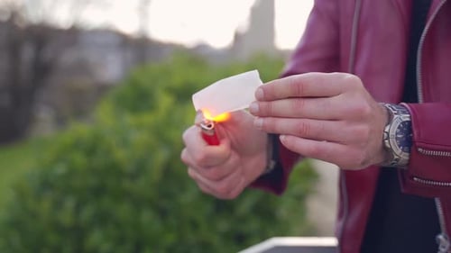 Street magic performance magic illusion trick burning up a piece of paper turning it into a red ball