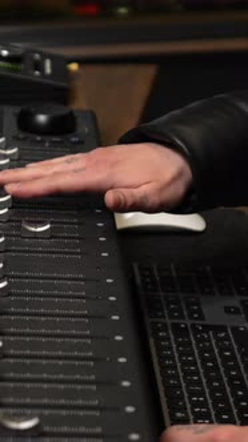 Music producer mixing audio track on digital console