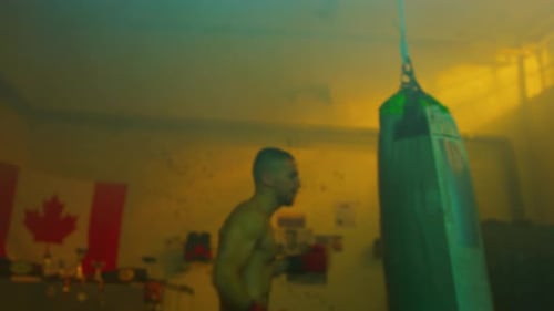 Focused athlete training with punching bag in gym setting