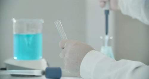 Scientist Drops Liquid Into Test Tube in Laboratory